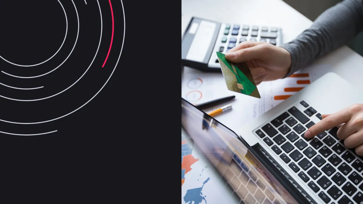 Person shopping online using a laptop and credit card, with charts and a calculator nearby.