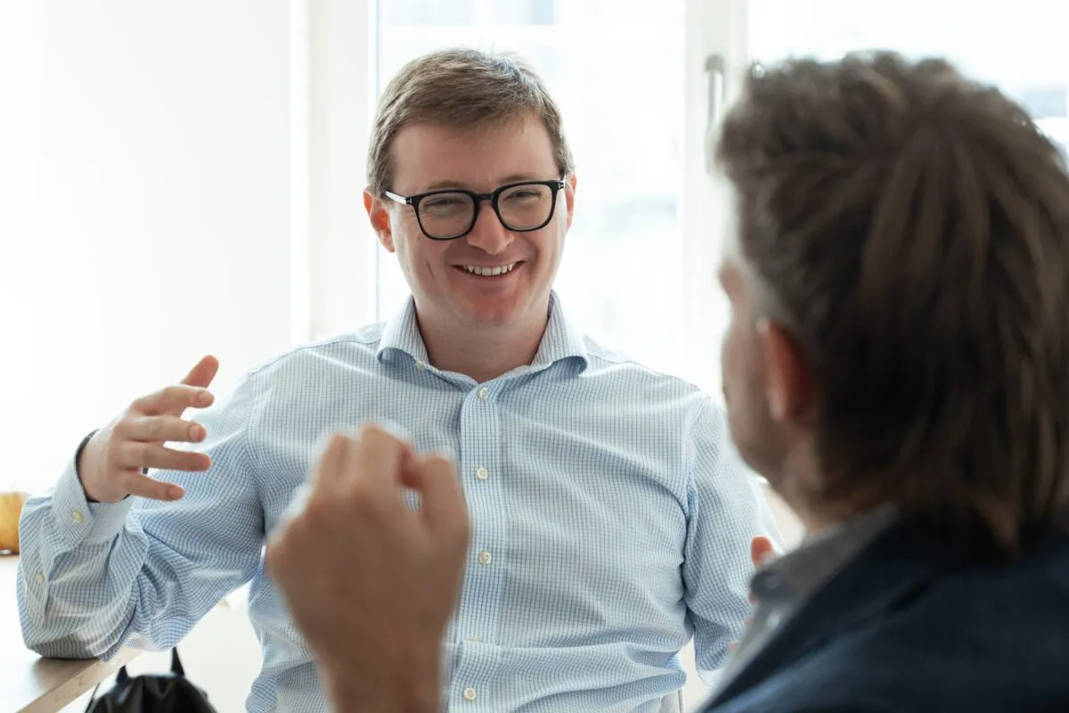 Two colleagues having a lively discussion in a bright office setting.