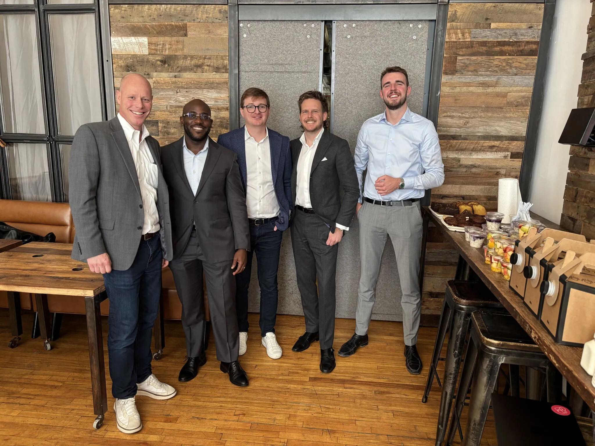 Business team smiling in modern office, displaying camaraderie and professional attire.