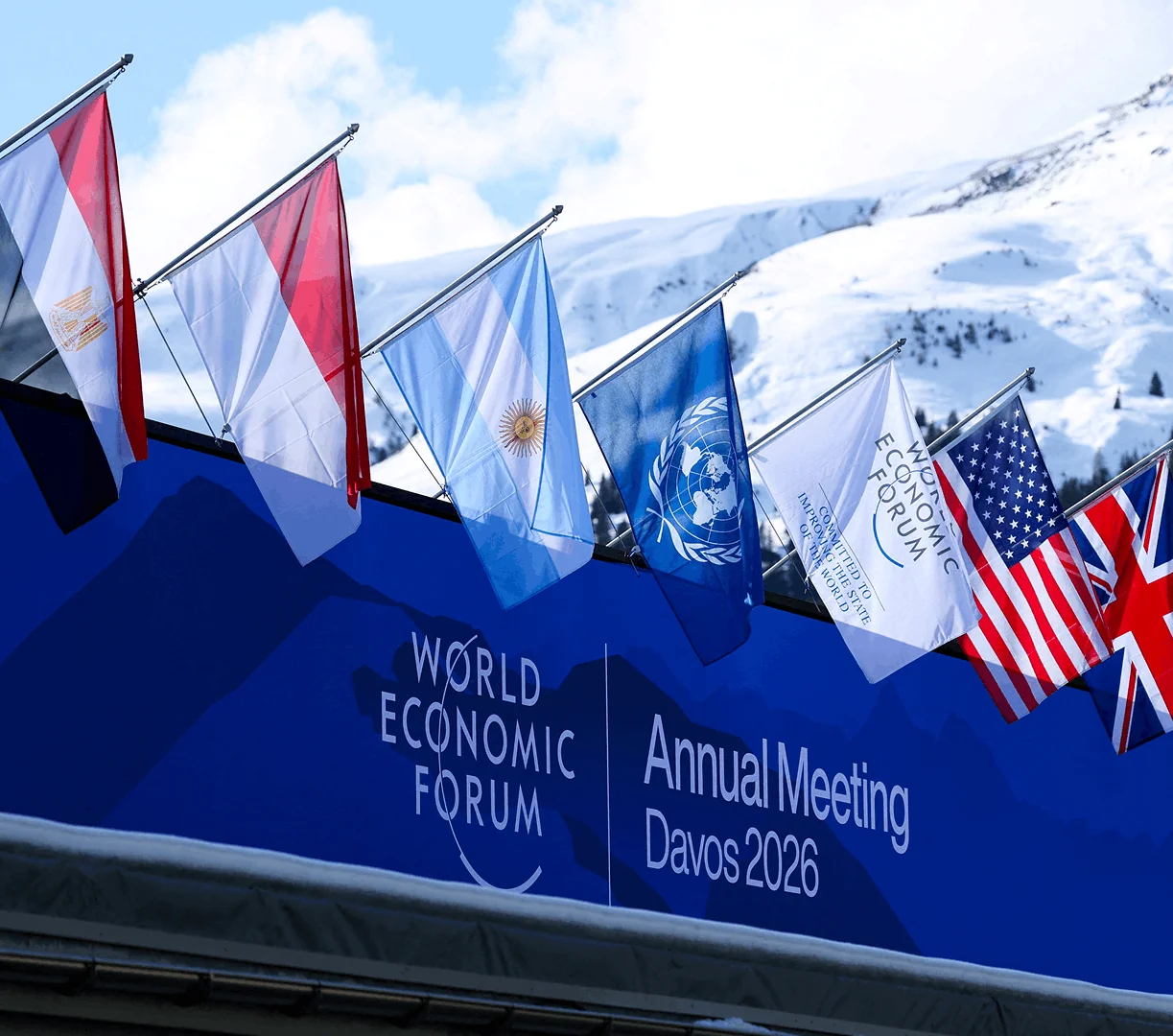 Flags at World Economic Forum 2026 Annual Meeting in Davos against snowy mountain backdrop.