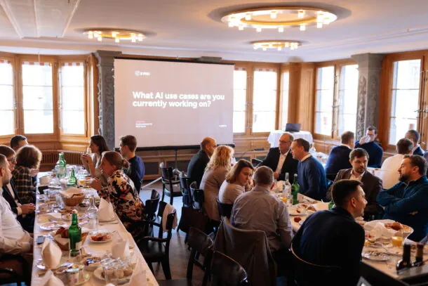 Business professionals discuss AI use cases at a conference table with presentation in background.